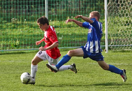 Hráč Spartaku Hluk v modrobílém dresu v souboji o míč